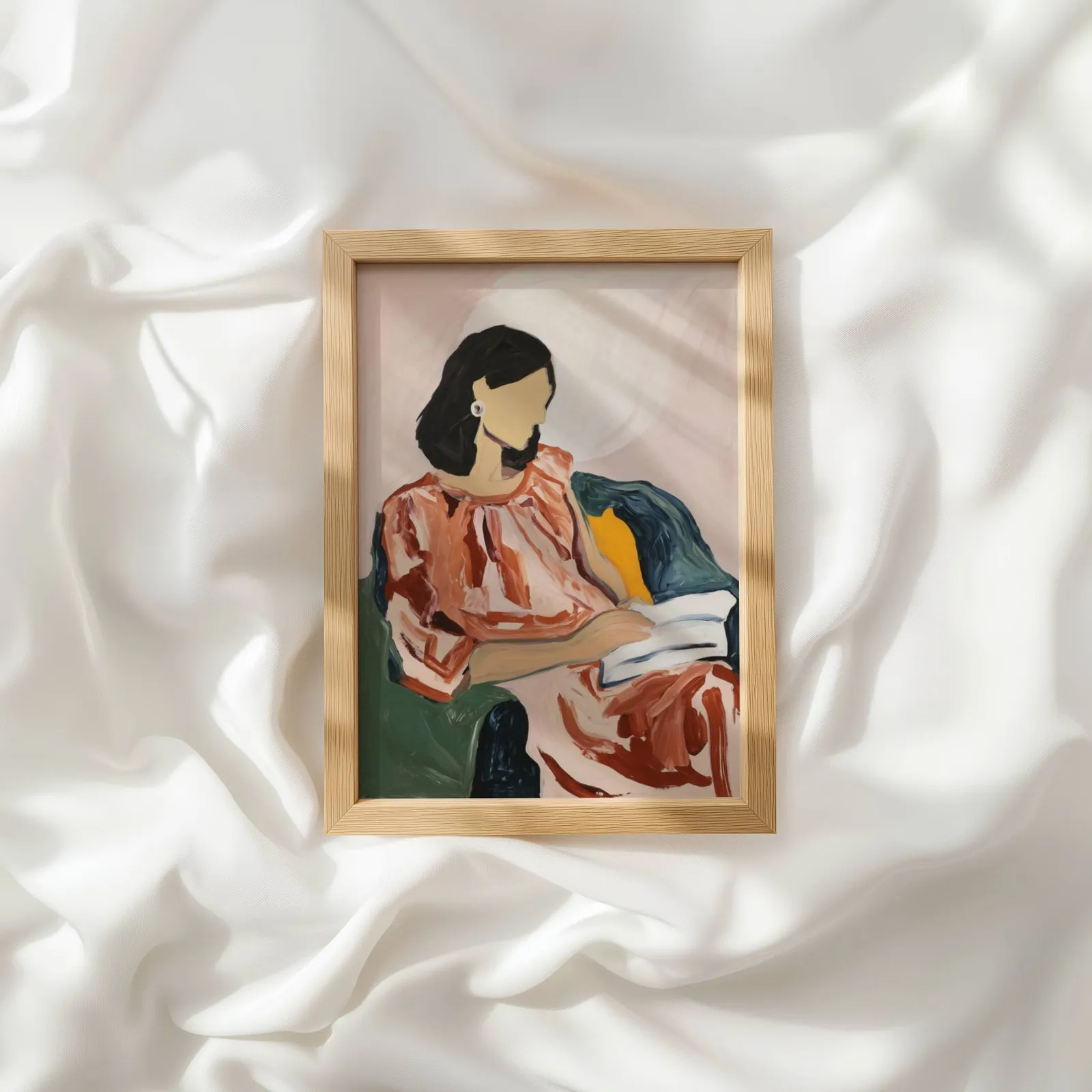 abstract woman reading portrait wall art, resting atop rumpled white silky fabric